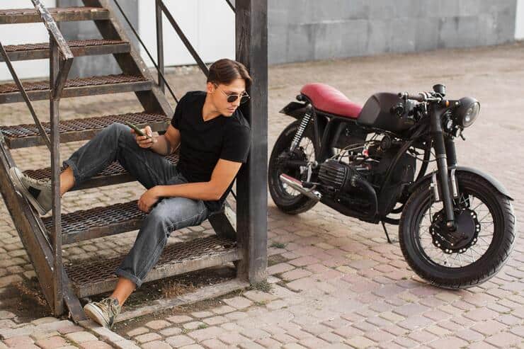 ragazzo seduto sulle scale accanto a una moto